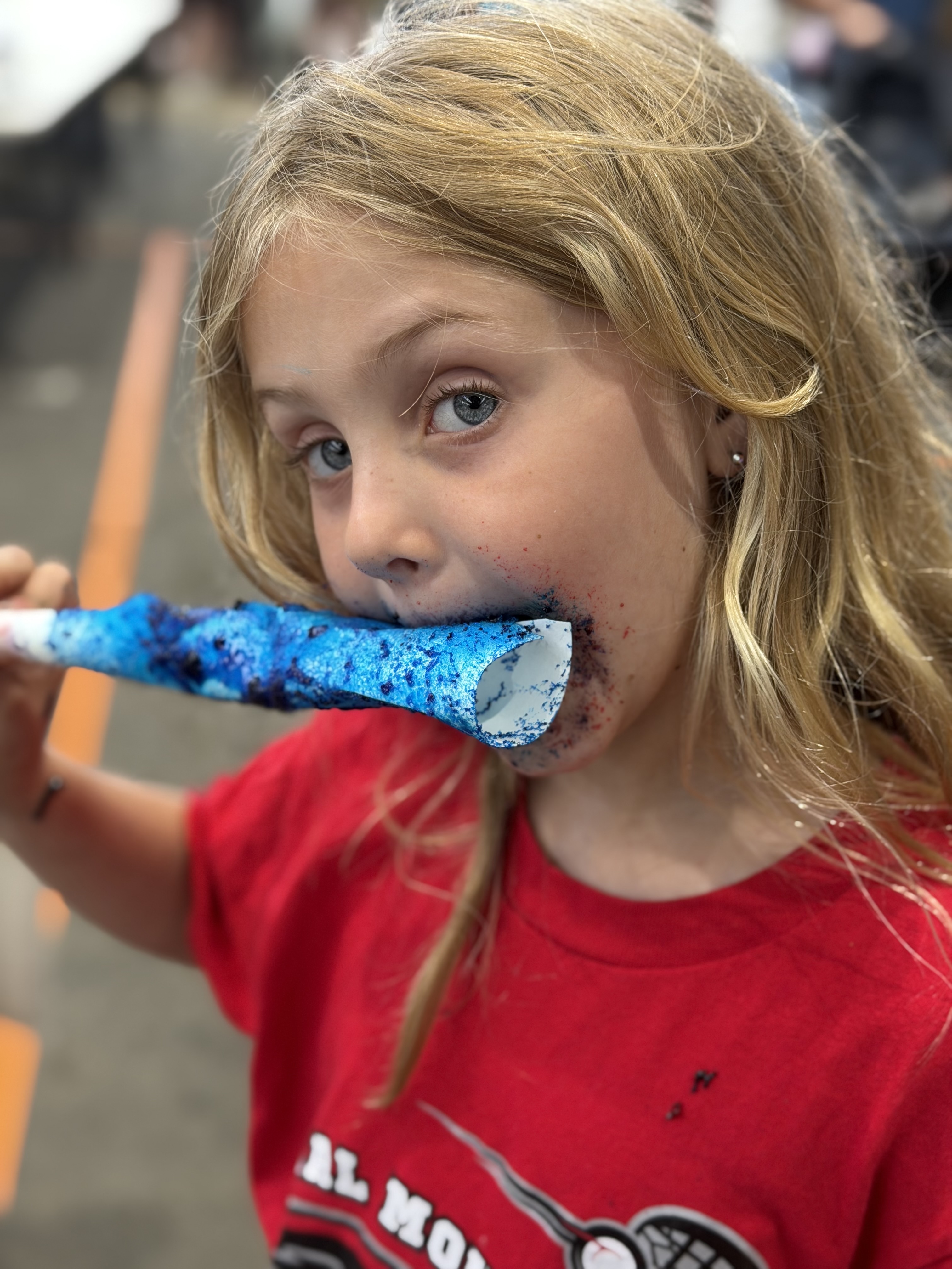 Girl eating a blue and purple cotton candy cone
