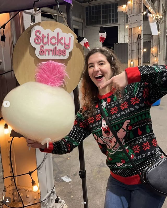 Customer pointing at the Sticky Smiles sign at a holiday event